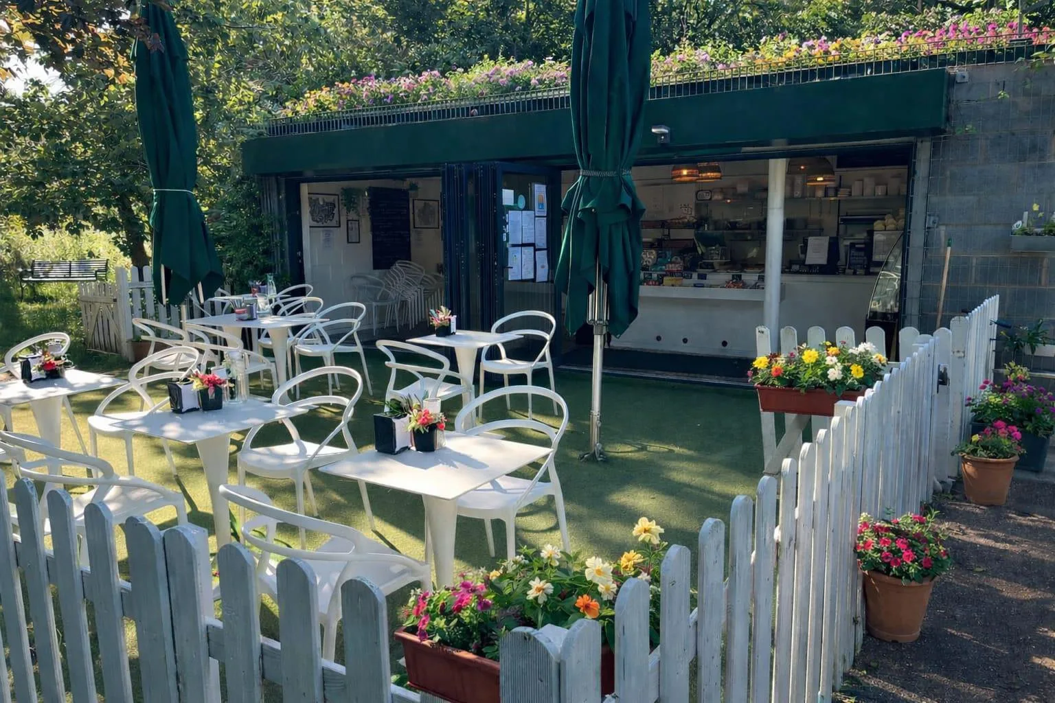 East Greenwich Pleasaunce — terrace with white chairs and flowers on a sunny day