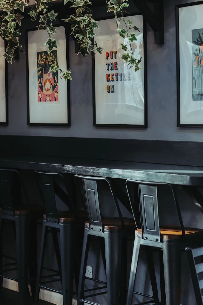 Framed prints and a ‘Put the kettle on’ sign inside the café
